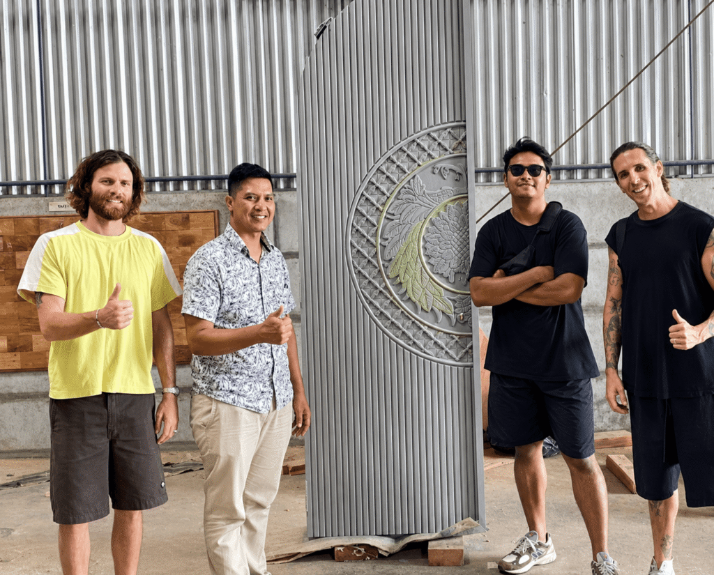 International buyer inspecting custom solid teak doors at an Indonesian door factory